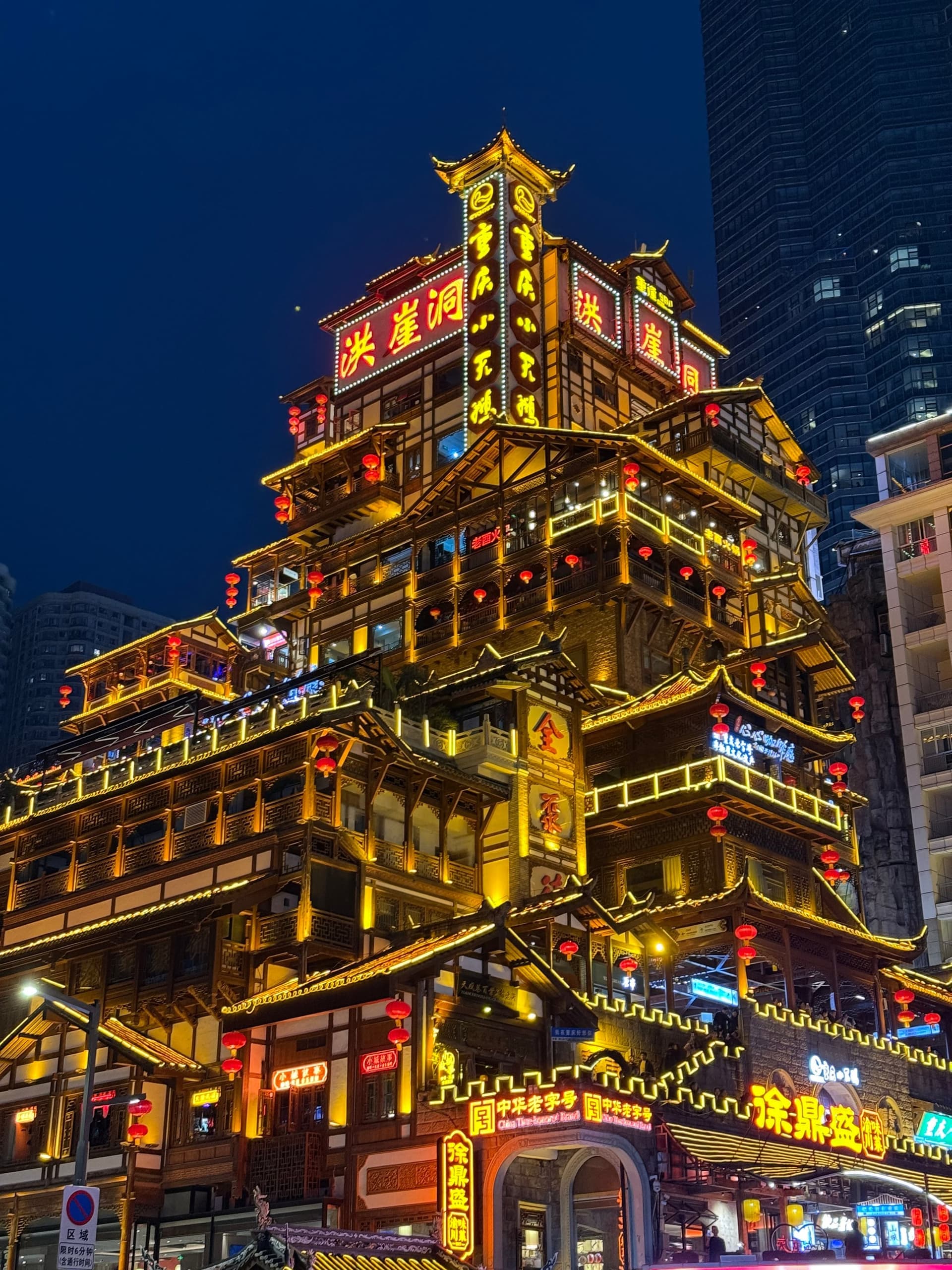 Vue nocturne d'Hongyadong depuis un angle rapproché, avec les enseignes lumineuses et les tours en arrière-plan