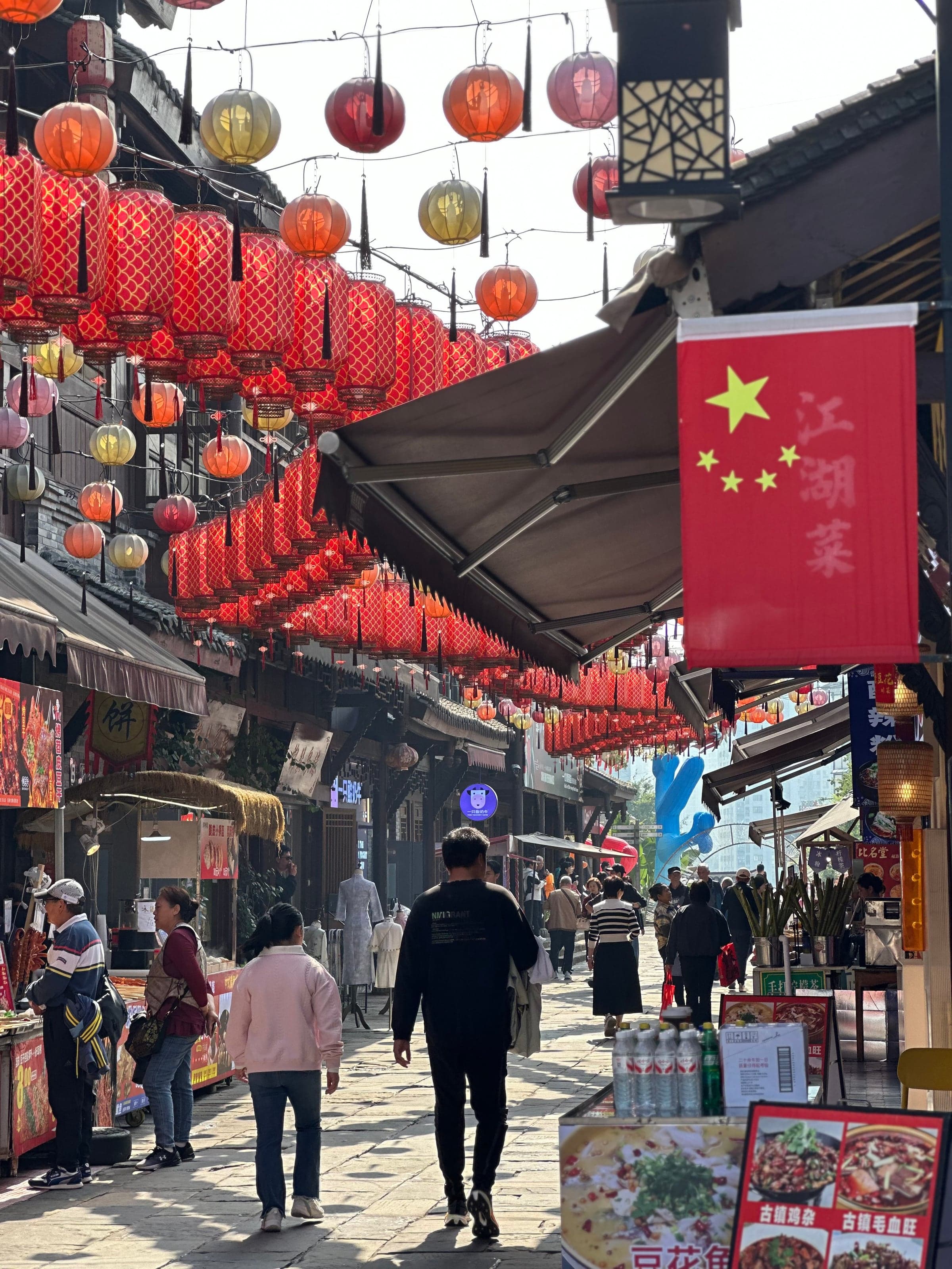 Allée de Ciqikou couverte de lanternes rouges avec des passants et des boutiques de rue