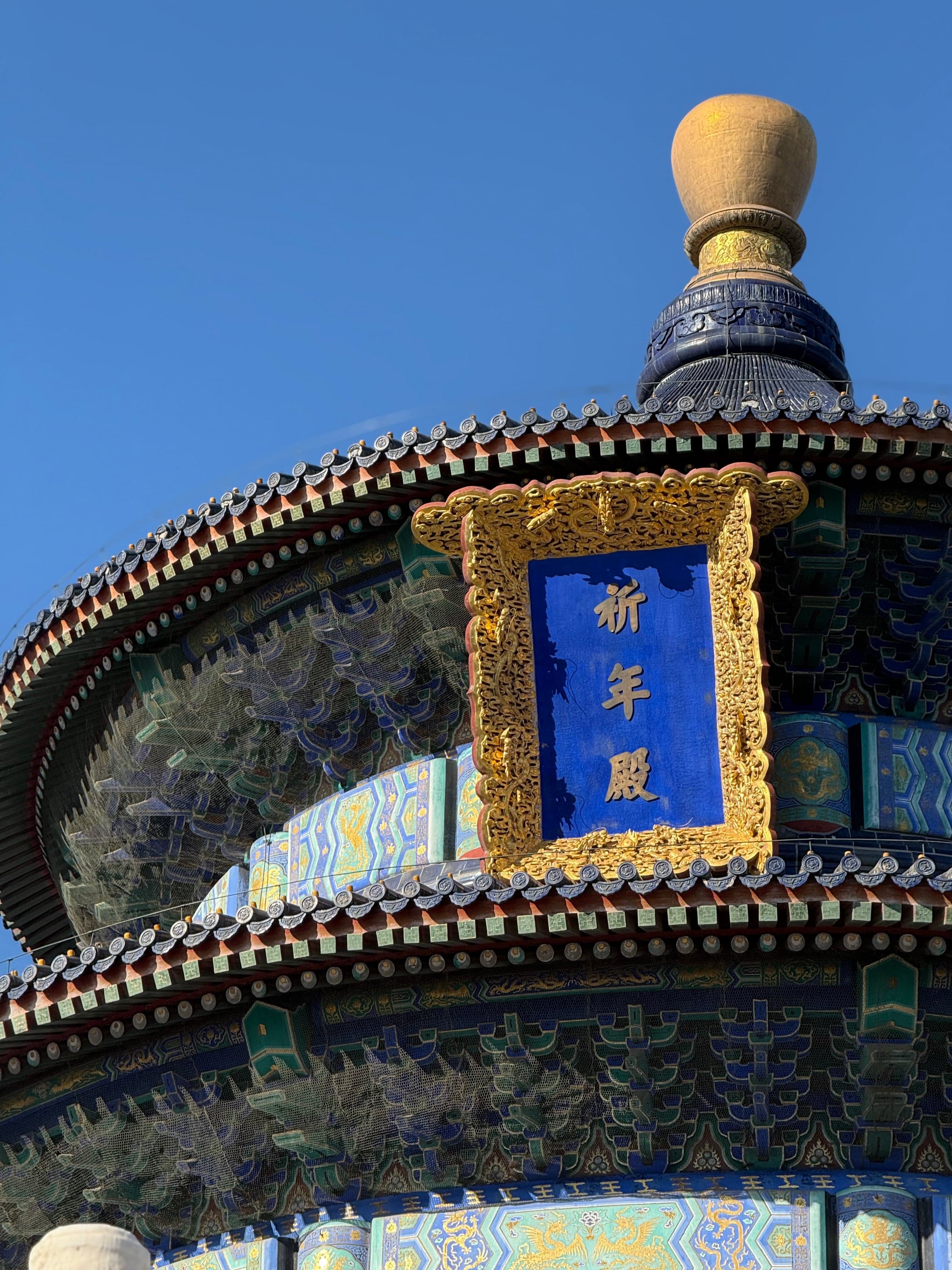 Gros plan sur la plaque dorée 祈年殿 (Salle des Prières pour les Bonnes Récoltes) au Temple du Ciel de Pékin, calligraphie chinoise sur fond bleu
