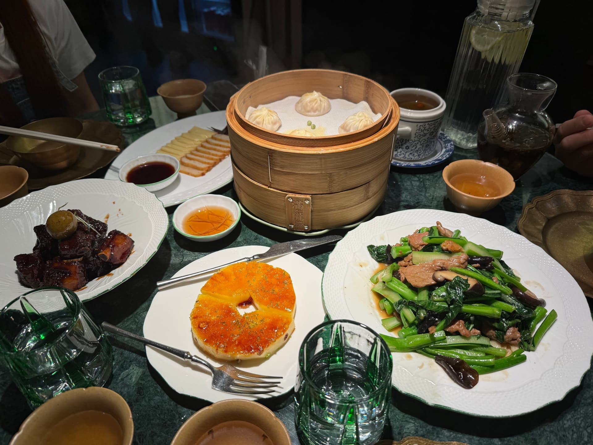 Repas chinois à table de restaurant à Shanghai, raviolis xiaolongbao, plats de viande braisée et légumes verts