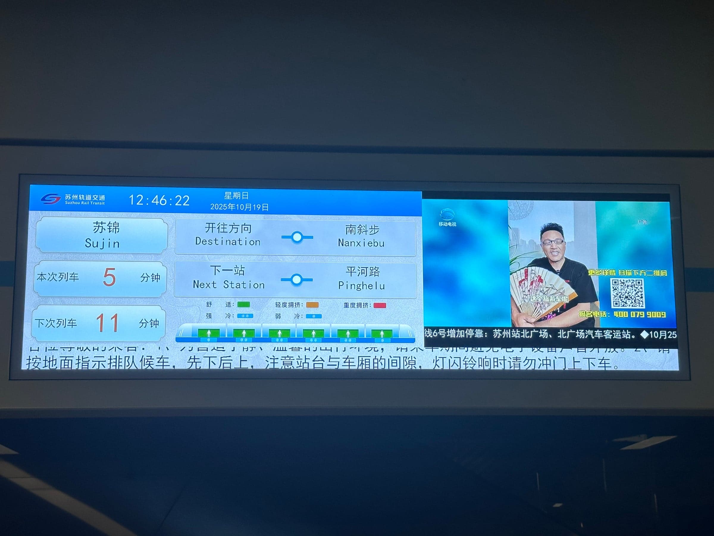 Écran de quai du métro de Suzhou affichant les noms de stations en caractères chinois doublés en pinyin, temps d'attente des deux prochaines rames et niveau d'affluence par wagon