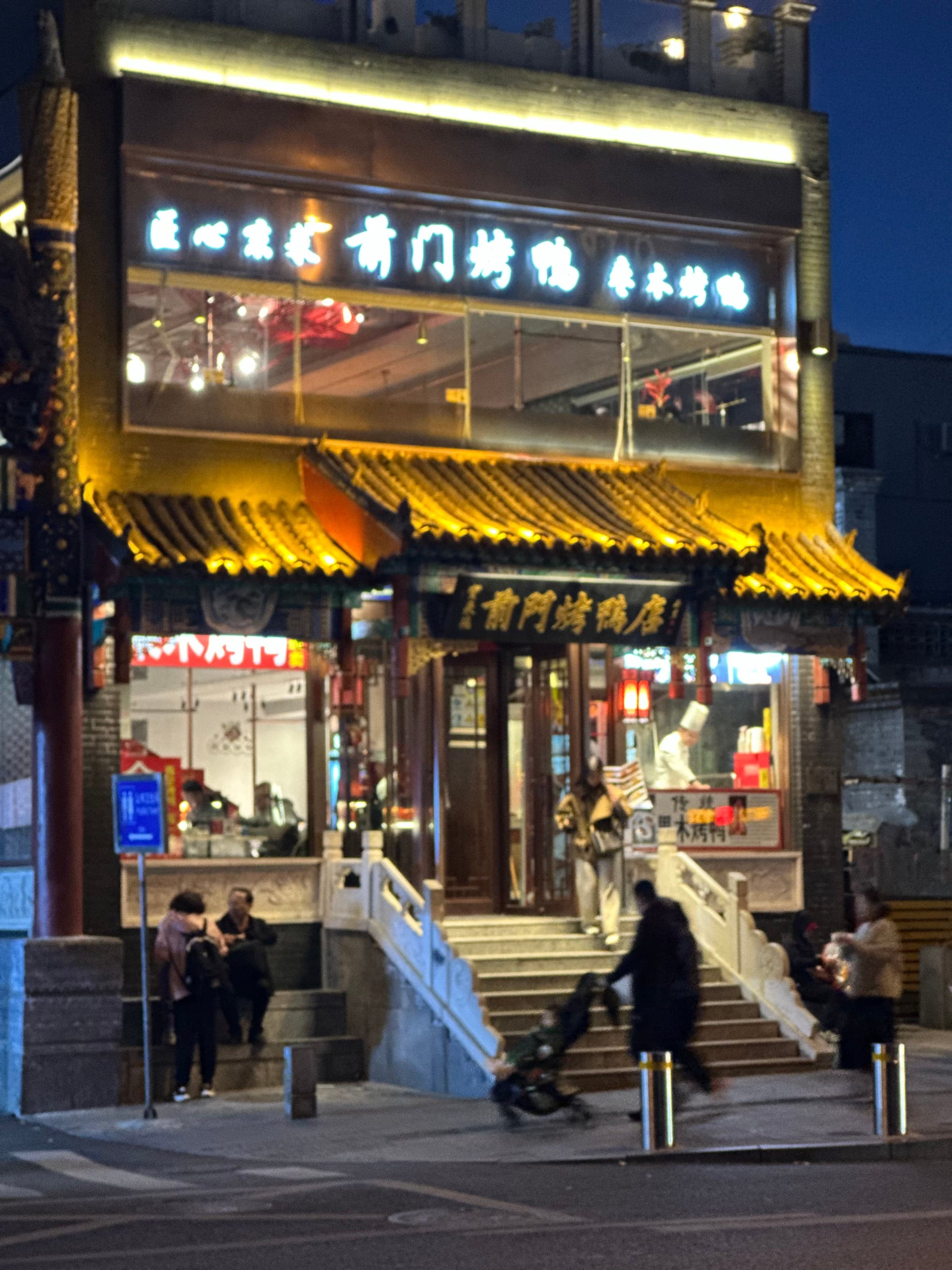 Façade illuminée nuit d'un restaurant de canard laqué (烤鸭店) près de la porte Qianmen à Pékin, enseignes lumineuses traditionnelles