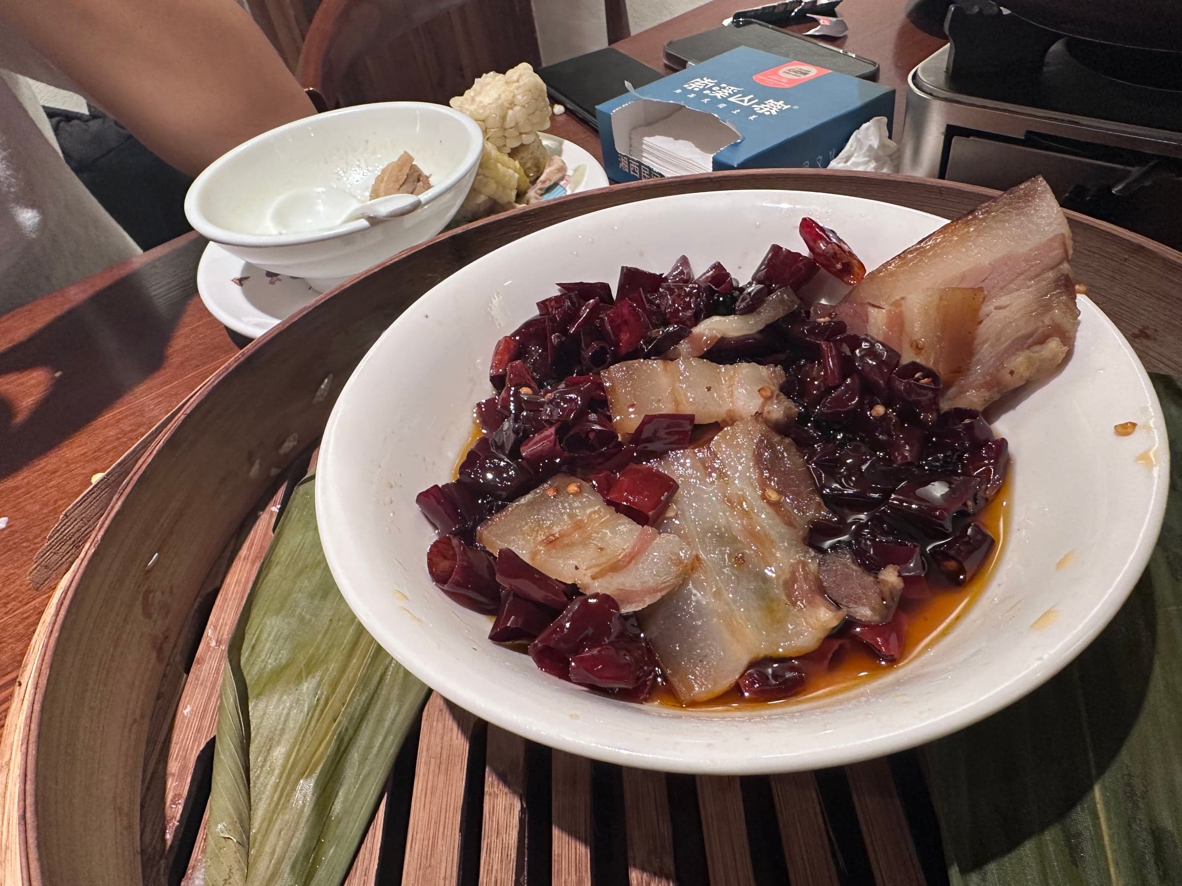 Plat de porc laqué aux tranches de piment séché dans une assiette blanche, cuisine du Hunan