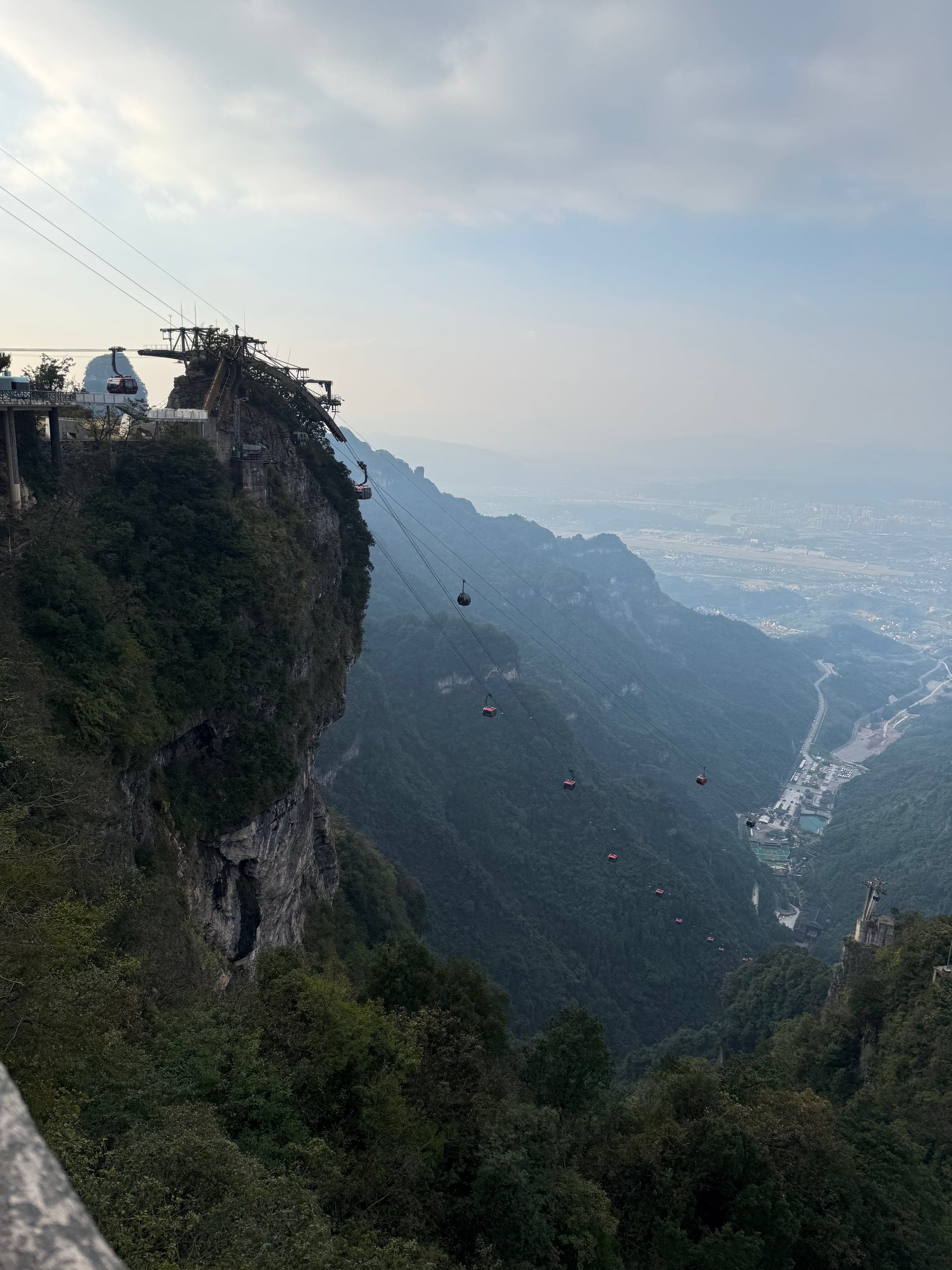 Cabines de téléphérique descendant le long d'une falaise vertigineuse depuis une station perchée, montagne Tianmen