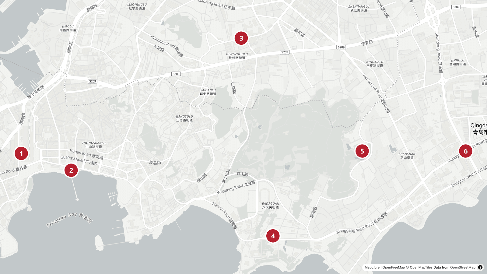 Carte du centre de Qingdao : la gare et la jetée de Zhanqiao à l'ouest, la brasserie Tsingtao au nord, Badaguan et la première plage sur la côte sud, le monastère de Zhanshan et May Fourth Square à l'est
