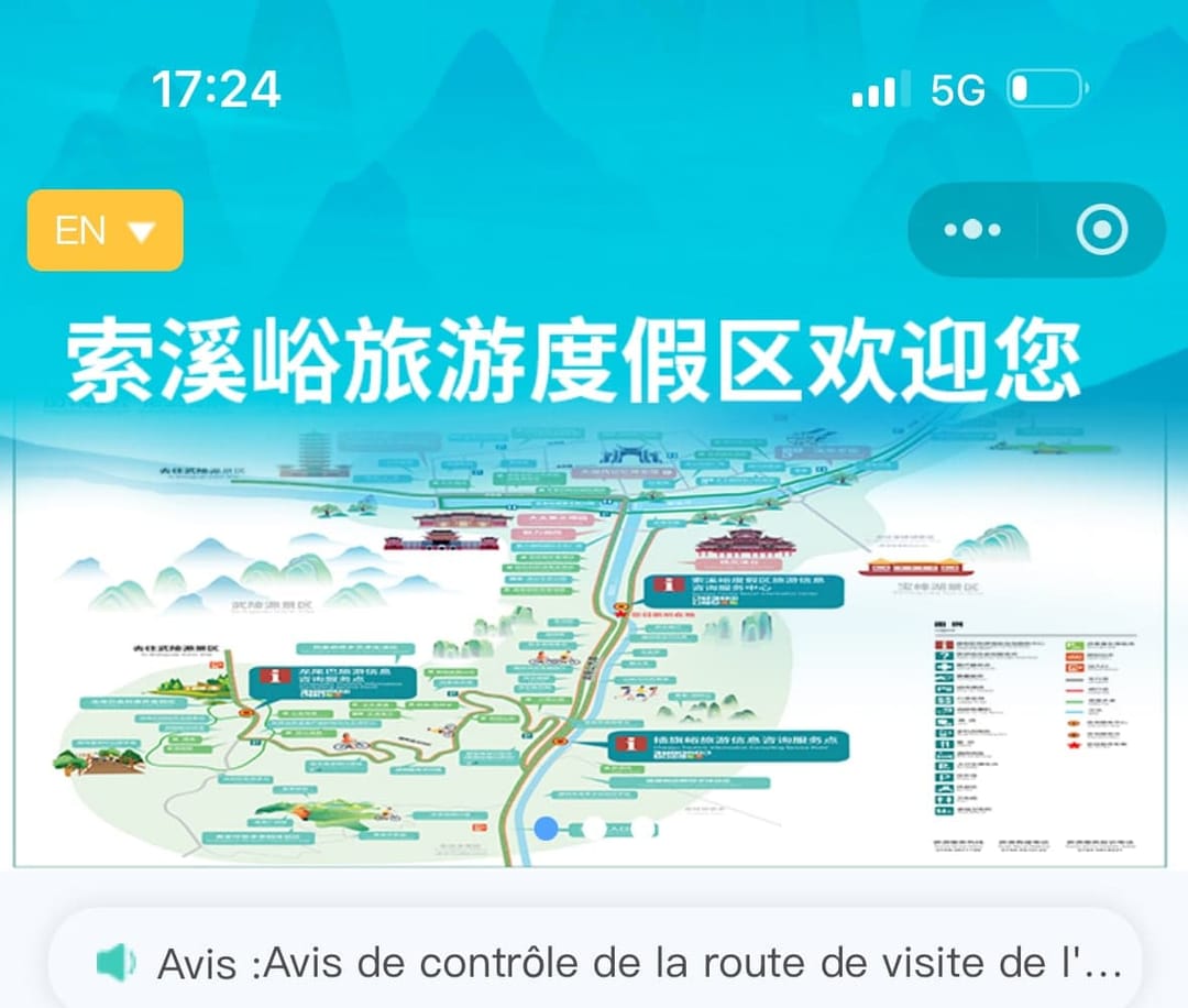 Écran d'accueil du mini-programme officiel de la zone touristique de Suoxiyu à Zhangjiajie : sélecteur de langue EN en haut à gauche, titre en chinois et plan illustré du parc avec ses navettes et ses points d'information