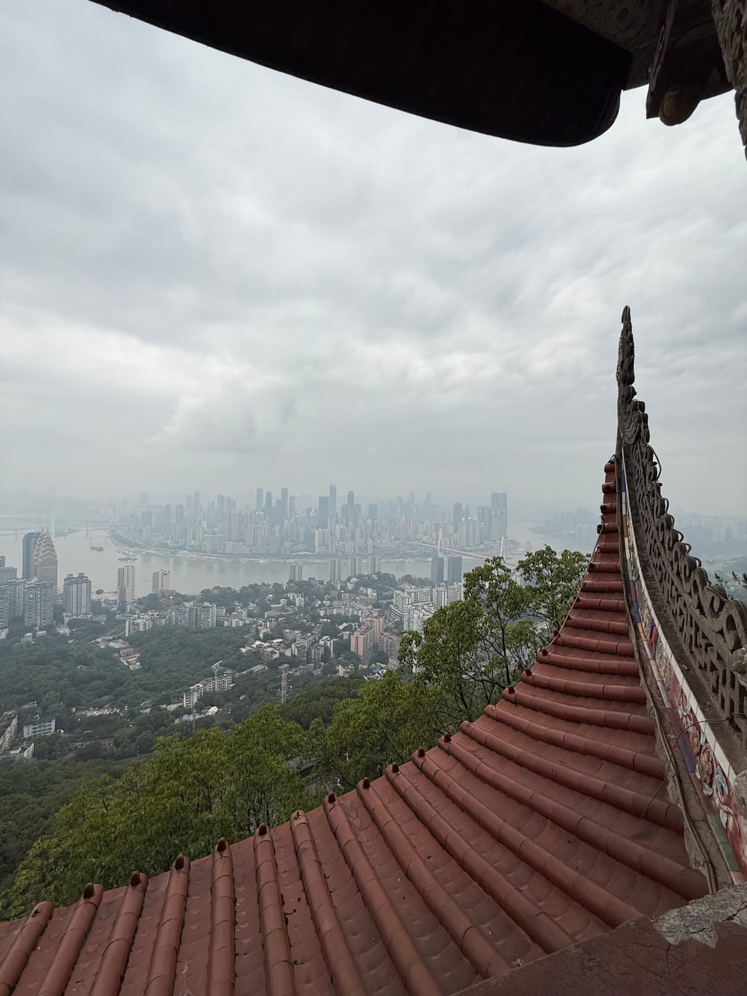 Vue panoramique sur la skyline brumeuse de Chongqing depuis le toit de tuiles rouges du temple de Laojun Dong