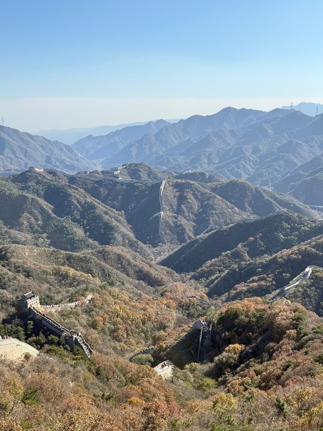 Panorama de vallées boisées en habit d'automne autour de Badaling, plusieurs segments de la Grande Muraille visibles sur les crêtes successives