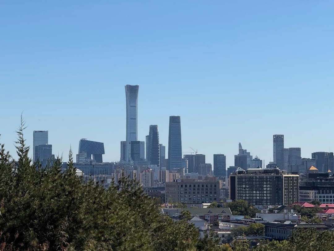 Gratte-ciel du quartier d'affaires de Pékin vus depuis Jingshan, dont la tour China Zun au profil galbé, au-dessus d'une masse d'arbres