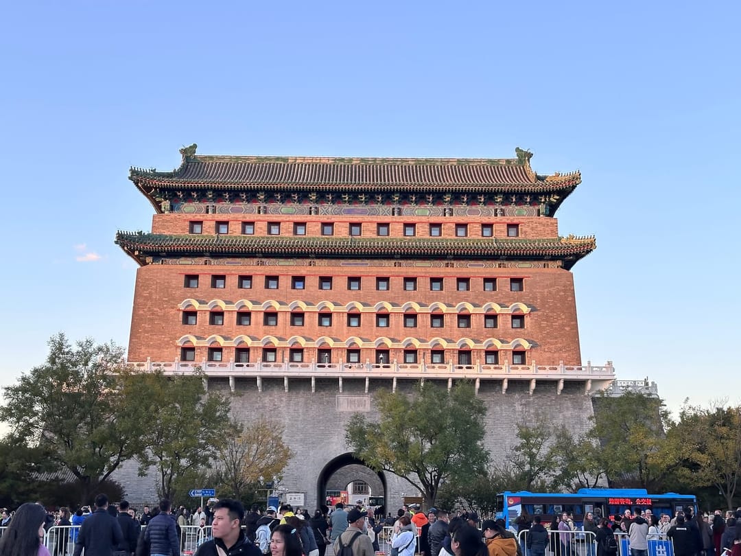 Porte historique de Qianmen à Pékin, architecture monumentale impériale à deux étages aux briques rouges et toits jaunes, foule au pied