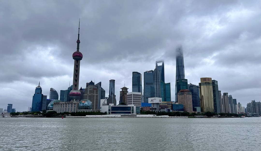 Ligne d'horizon de Pudong vue du Bund par ciel couvert, la Perle de l'Orient à gauche puis la Jin Mao Tower, le World Financial Center et la Shanghai Tower, une péniche sur le Huangpu