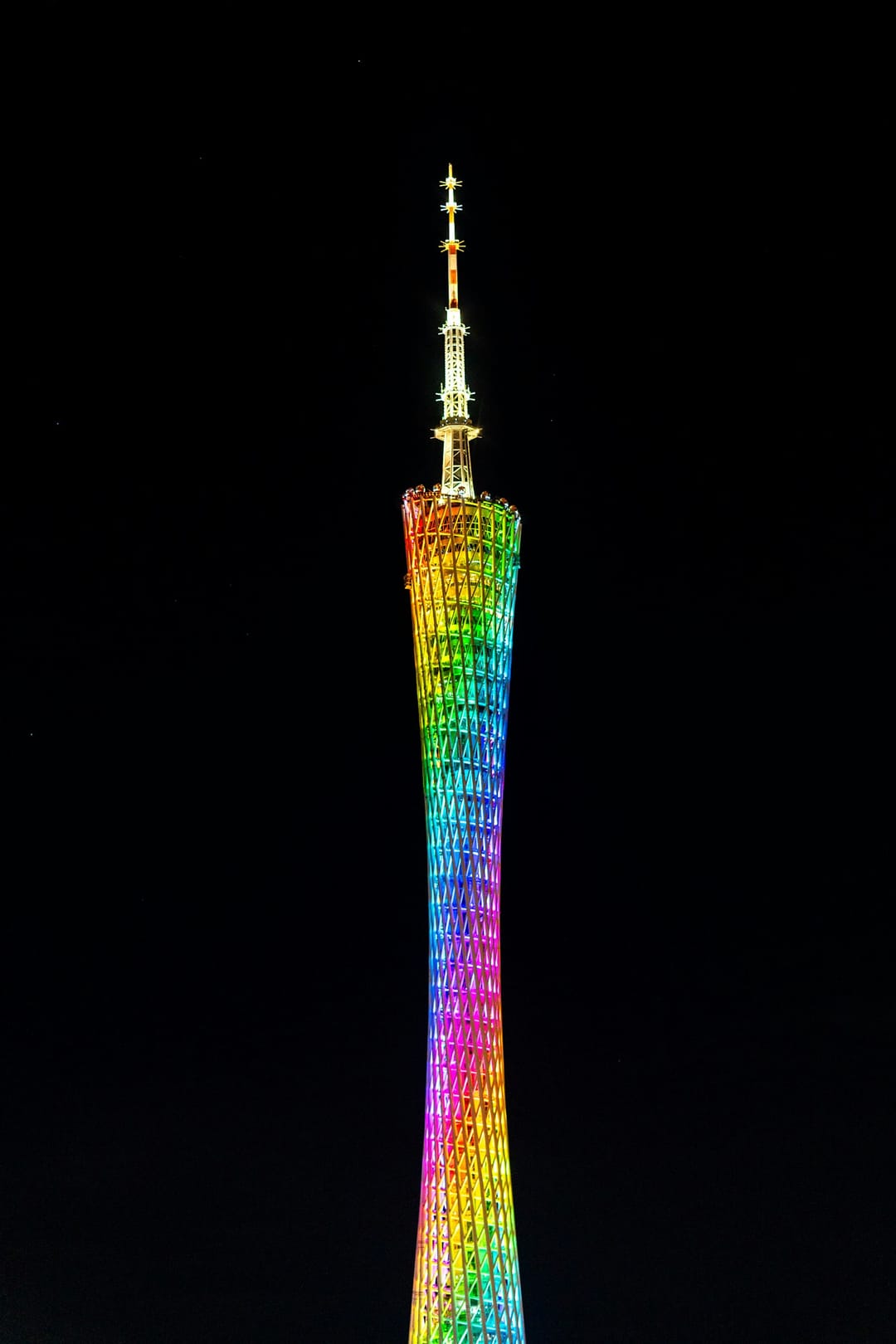 La Canton Tower illuminée de couleurs arc-en-ciel la nuit à Guangzhou, structure en treillis torsadé se détachant sur un ciel noir
