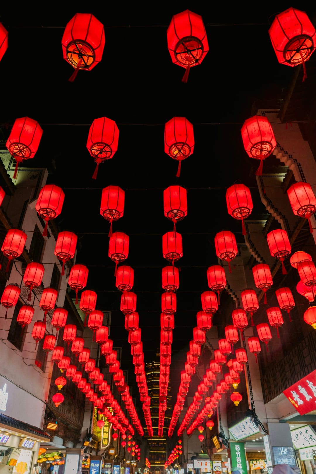 Rues couvertes de rangées de lanternes rouges illuminées la nuit pour une fête chinoise